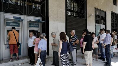 Customers queue to withdraw cash from an ATM outside a main branch of the National Bank of Greece SA in Thessaloniki, Greece, on June 29, 2015. Greece shut its banks and imposed capital controls in an announcement designed to avert the collapse of its financial system. Kontantinos Tsakalidis/Bloomberg