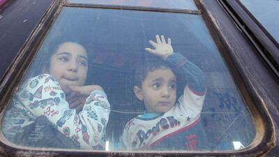 Palestinian children hoping to cross into Egypt, look out of a bus window at the Rafah crossing between Egypt and the southern Gaza Strip. Ahmed Zakot / Reuters