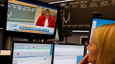 A stock broker in Frankfurt follows the verdict of a German court, which paved the way for the creation of a €500 billion (Dh2.36 trillion) fund to fight the euro-zone crisis. Boris Roessler / EPA