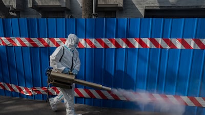 A health worker wears a protective suit as he disinfects an area outside a barricaded community that was locked down during the Covid-19 pandemic in 2022 in Beijing, China. Getty Images
