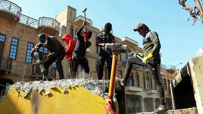 Protesters smash concrete walls that were set by security forces to close Rasheed street on Thursday. AP Photo