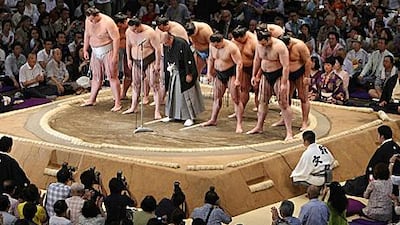 Hanaregoma, centre, chairman of the sumo association, and high-ranking sumo wrestlers bow at the start of the 15-day tournament. The sport is hoping to put a bout-fixing scandal behind it.