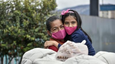 Venezuelan migrants huge each other as they line up outside the Bogota's northern bus terminal to buy bus tickets to get to the border and return to their country due to the novel coronavirus Covid-19 pandemic in Bogota, Colombia. Getty Images