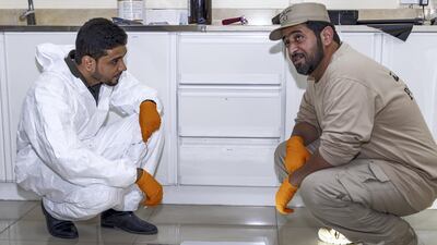 Mohammed Waheedi and Ali Al Shamsi of the Ajman Police Crime Scenes Investigative Unit demonstrate how they collect dust prints from crime scenes. Navin Khianey for The National