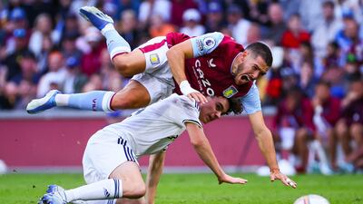Aston Villa's Emiliano Buendia falls over Leeds United's Archie Gray. AFP