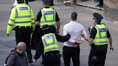 A man is arrested before the cortege carrying the coffin of the late Queen Elizabeth II passes in Edinburgh, Scotland. Getty Images