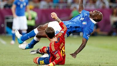 Italy's Mario Balotelli, top, is fouled by Spain's Sergio Ramos during the Euro 2012 soccer championship final between Spain and Italy in Kiev, Ukraine, Sunday, July 1, 2012. (AP Photo/Michael Sohn)