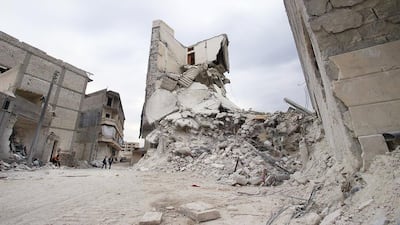 Residents walk near damaged buildings in Kafr Hamra village, northern Aleppo countryside, Syria February 27, 2016. REUTERS/Abdalrhman Ismail