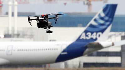 A drone flies near an Airbus A340 aircraft. The US is looking to open up the commercial use of drones. Regis Duvignau/Reuters