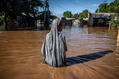 A woman wades through flood waters at an inundated residential area in Garissa, east-central Kenya. AFP