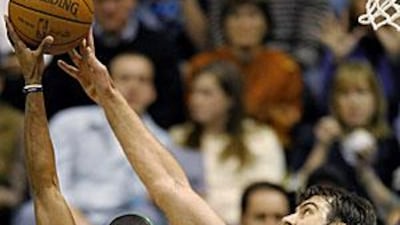 Boston's Rajon Rondo has his shot blocked by Mehmet Okur, the Utah Jazz centre.