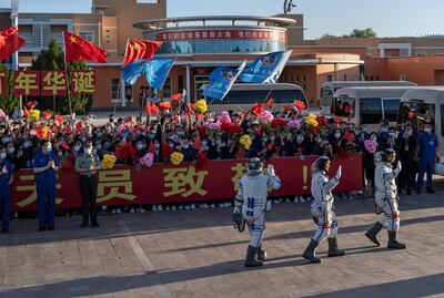 Chinese astronauts Nie Haisheng, Liu Boming and Tang Hongbo wave at a departure ceremony before the launch. Getty Images