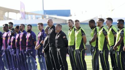 Players of Qalandars, right, and Deccan Gladiators observing a minute of silence in memory of the late Sheikh Sultan bin Zayed Al Nahyan before the start of their Abu Dhabi T10 match on Tuesday. Pawan Singh / The National