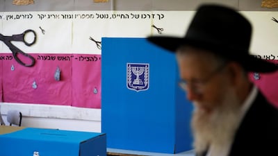 An ultra-Orthodox Jewish man walks next to a voting booth in Jerusalem. Reuters