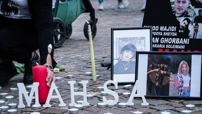 A person places a candle during the demonstration in Turin. EPA