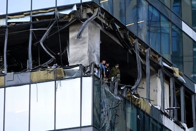 Investigators examine a damaged skyscraper in Moscow's business district after a reported drone attack on July 30. AP
