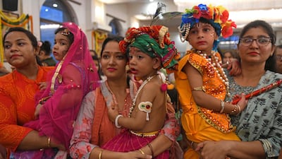Devotees carry their children dressed as Krishna and Radha. AFP