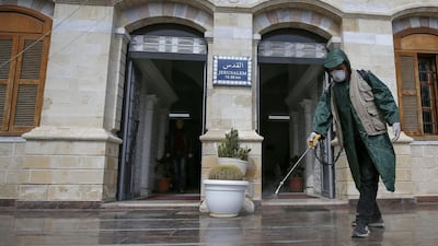 A Palestinian municipal worker sprays disinfectant in the Gaza City Park on March 9, 2020. AFP