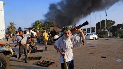 A rebel fighter carry a gun inside the main Moammar Gadhafi compound in Bab al-Aziziya in Tripoli, LIbya, Tuesday, Aug. 23, 2011. Libyan rebels stormed Moammar Gadhafi's main military compound in Tripoli Tuesday after fierce fighting with forces loyal to???