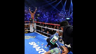 Manny Pacquiao lays face down on the mat after being knocked out in the sixth round as Juan Manuel Marquez celebrates during their welterweight bout. Al Bello / Getty Images