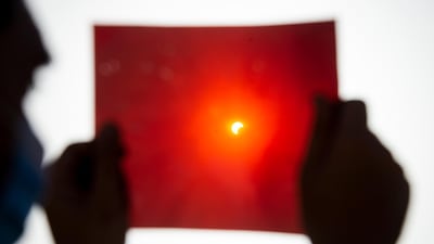A man uses an X-ray plate to observe an annular partial solar eclipse in Cairo, Egypt. EPA