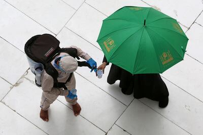 A worker offers water to a pilgrim performing the farewell tawaf of the Kaaba at the Grand Mosque in Makkah in 2021. AFP