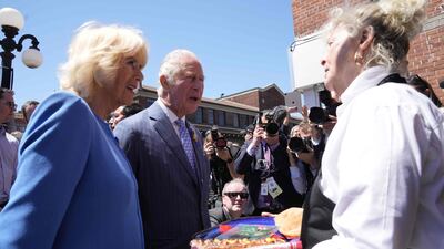 Britain's Prince Charles and Camilla, Duchess of Cornwall, are served beaver tail pastries at the Byward Market in Ottawa on May 18, 2022. AFP