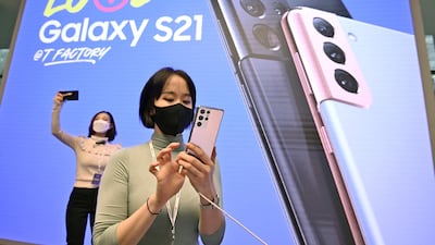 A woman looks at the Samsung Galaxy S21 smartphone during a domestic launch event at a flagship store of SK Telecom in Seoul on January 22, 2021. (Photo by Jung Yeon-je / AFP)