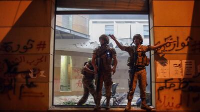 Lebanese army soldiers stand guard by a shattered window inside the Lebanese Banks Association (ABL) headquarters during a demonstration. Bloomberg