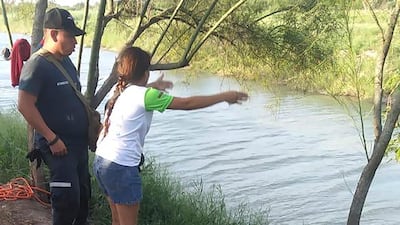 Tania Vanessa Avalos of El Salvador speaks with Mexican authorities after her husband and toddler daughter were swept away by the current in Matamoros, Mexico, while trying to cross the Rio Grande to Brownsville, Texas. AP Photo