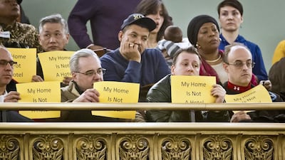 Opponents of Airbnb hold signs that reads “My home Is Not A Hotel,” during a hearing in New York. With home-as-hotel sites like Airbnb doing booming business, New York City lawmakers are holding a hearing to scrutinising how the trend affects the housing market and economy. Bebeto Matthews / AP Photo