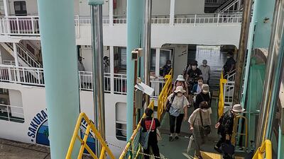 Evacuees disembark from a ferry at a port in Kagoshima City after the eruption. AFP