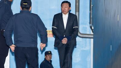 Shin Dong-bin, chairman of Lotte Group, right, walks towards a prison bus at the Seoul Central District Court after he was convicted of bribery. SeongJoon Cho/Bloomberg