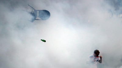 A bottle and chair are thrown as an England fan walks through tear gas in Marseille on Friday during the start of the Euro 2016 tournament. Carl Court / Getty Images / June 10, 2016