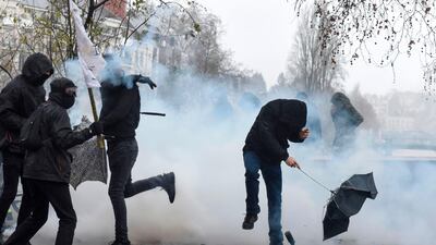 Demonstrators react as a tear gas canister lobbed by French anti-riot police officers lands at their feet during a protest in Nantes, western France. AFP