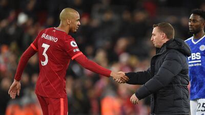 Liverpool's Brazilian midfielder Fabinho (L) shakes hands with Leicester City's Northern Irish manager Brendan Rodgers on the pitch after the English Premier League football match between Liverpool and Leicester City at Anfield in Liverpool, north west England on February 10, 2022. - Liverpool won the game 2-0. (Photo by Oli SCARFF / AFP) / RESTRICTED TO EDITORIAL USE. No use with unauthorized audio, video, data, fixture lists, club/league logos or 'live' services. Online in-match use limited to 120 images. An additional 40 images may be used in extra time. No video emulation. Social media in-match use limited to 120 images. An additional 40 images may be used in extra time. No use in betting publications, games or single club/league/player publications. /