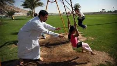 Mohammed al Shamsi plays with his children, Hamda and Naeema, at the Green Mubazzarah.