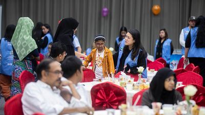 Volunteers welcome families to the iftar