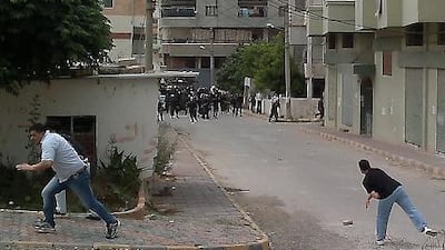 Men throw stones at riot police during clashes in the Mediterranean coastal town of Banias today, as Syria braced for more anti-government protests.