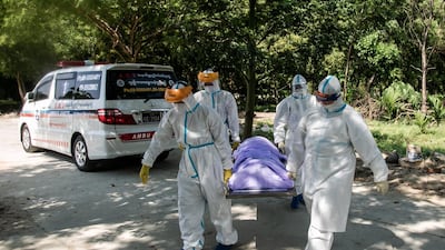 Volunteers wearing personal protective equipment (PPE) carry the body of a person suspected of dying from the Covid-19 coronavirus for their burial in the Hteinbin Muslim Cemetery in Yangon. AFP