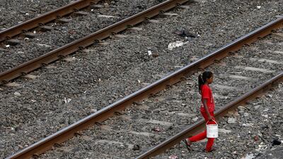 An Indian girl crossing train tracks in Mumbai, India. Rajanish Kakade / AP