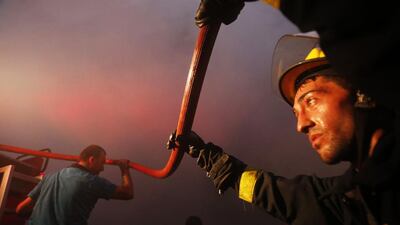 Lebanese fire fighters extinguish a flame at the site of a car bomb between the Bir el-Abed and Roueiss neighbourhoods, in the southern suburb of Beirut. AFP