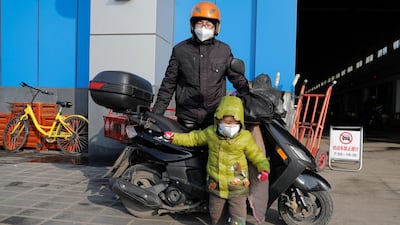 A man and his child wear protective masks at a market in Beijing, China. EPA