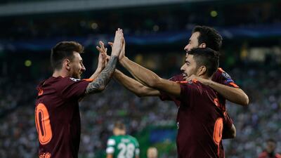 Barcelona's Lionel Messi and Luis Suarez celebrate after an own goal by Sporting's Sebastian Coates. Armando Franca / AP Photo