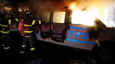 New York City firefighters spray water on a police van set ablaze during protests at Union Square, New York, US. EPA