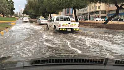 Traffic moves slowly through flood waters caused by rain on the slip road from 13th street to Muroor in Abu Dhabi. (Brian Kerrigan / The National)