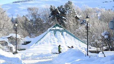 People walk past a building that has been snowed in. Getty Images