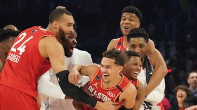 Team Giannis guard Trae Young of the Atlanta Hawks celebrates with teammates after making a shot at the halftime buzzer. Kyle Terada-USA TODAY