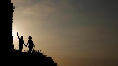 Tourists pose for a picture in the ruins of the ancient city of Byblos as the sun sets over the Mediterranean Sea, north of Beirut, Lebanon. Hassan Ammar / AP Photo