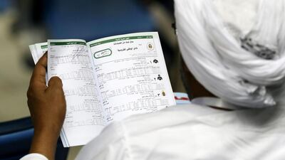 A gentleman reads the race card at a race meeting at Meydan Racecourse in Dubai on Thursday night.